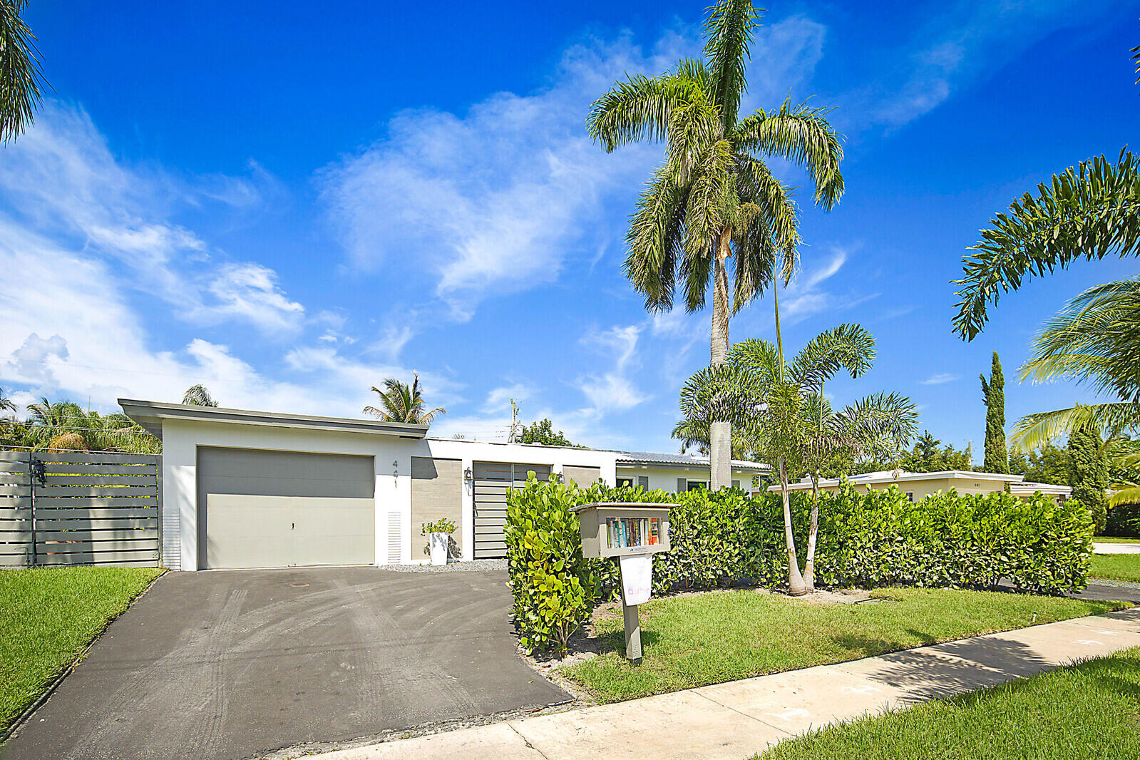 a front view of a house with a yard and potted plants