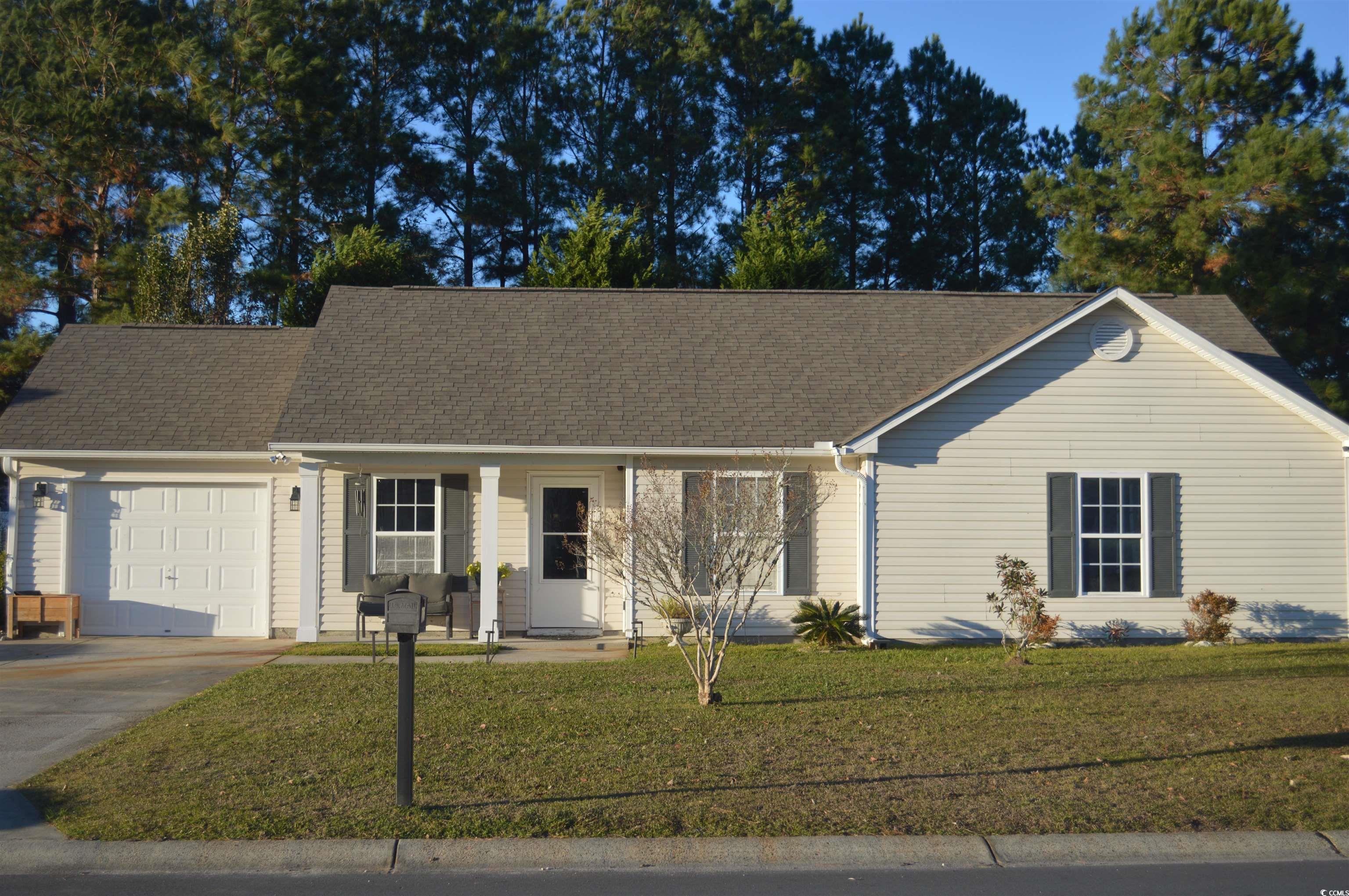 Ranch-style house with a front yard and a garage