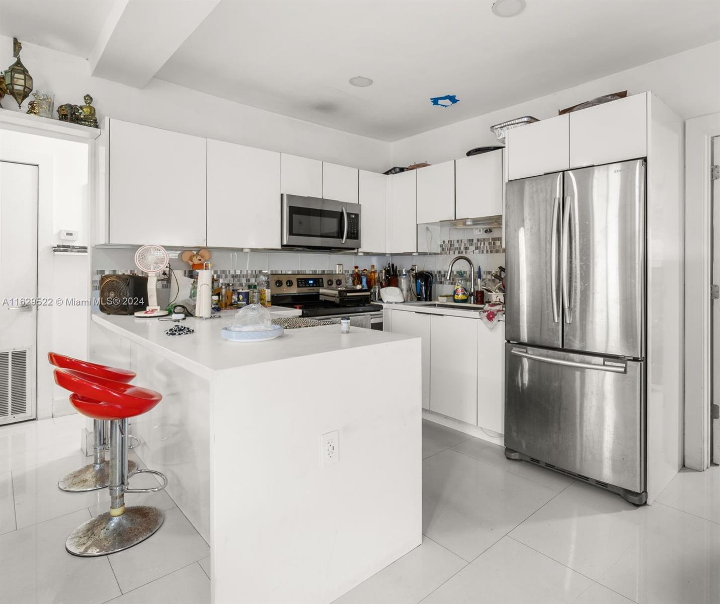 a kitchen with stainless steel appliances granite countertop a refrigerator a stove a sink and white cabinets