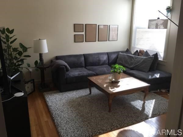 a living room with furniture rug and wooden floor