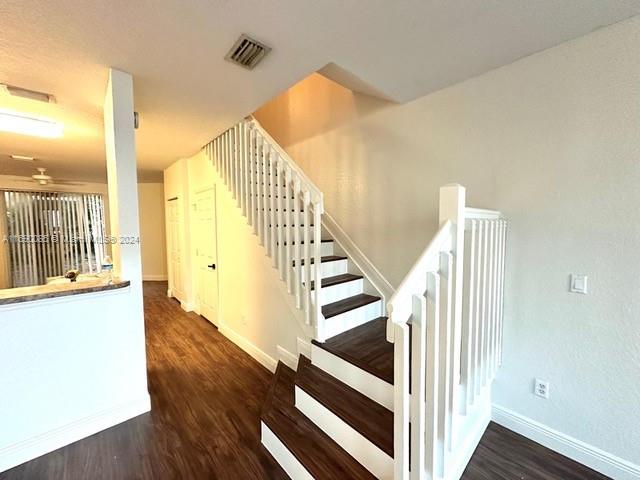 a view of a hallway with wooden floor and staircase