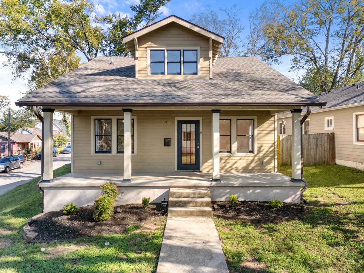 a front view of a house with a yard outdoor seating and garage