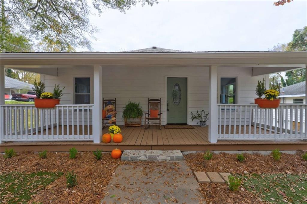 a view of a house with wooden deck and furniture