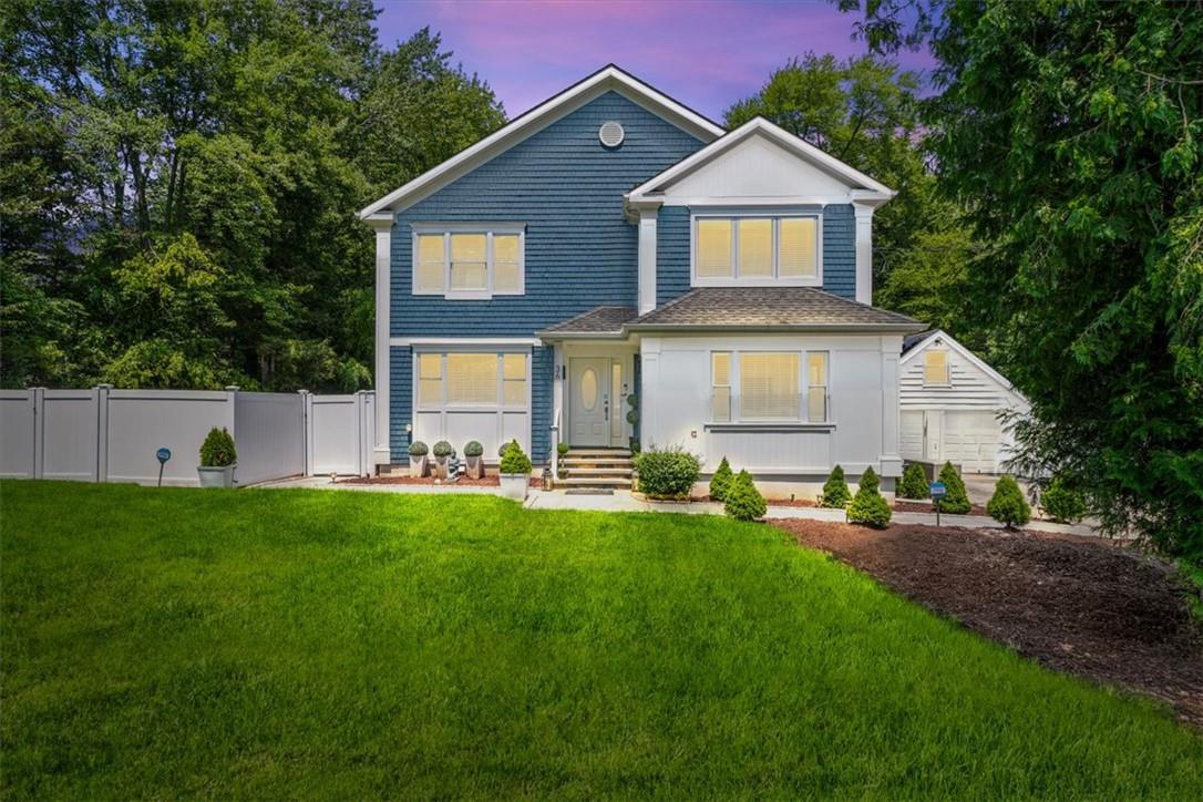 View of front of house with a yard and a garage