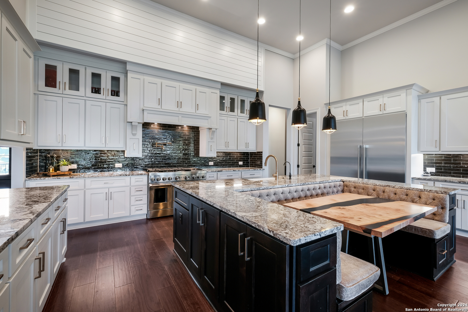 a open kitchen with stainless steel appliances granite countertop a table chairs sink and cabinets