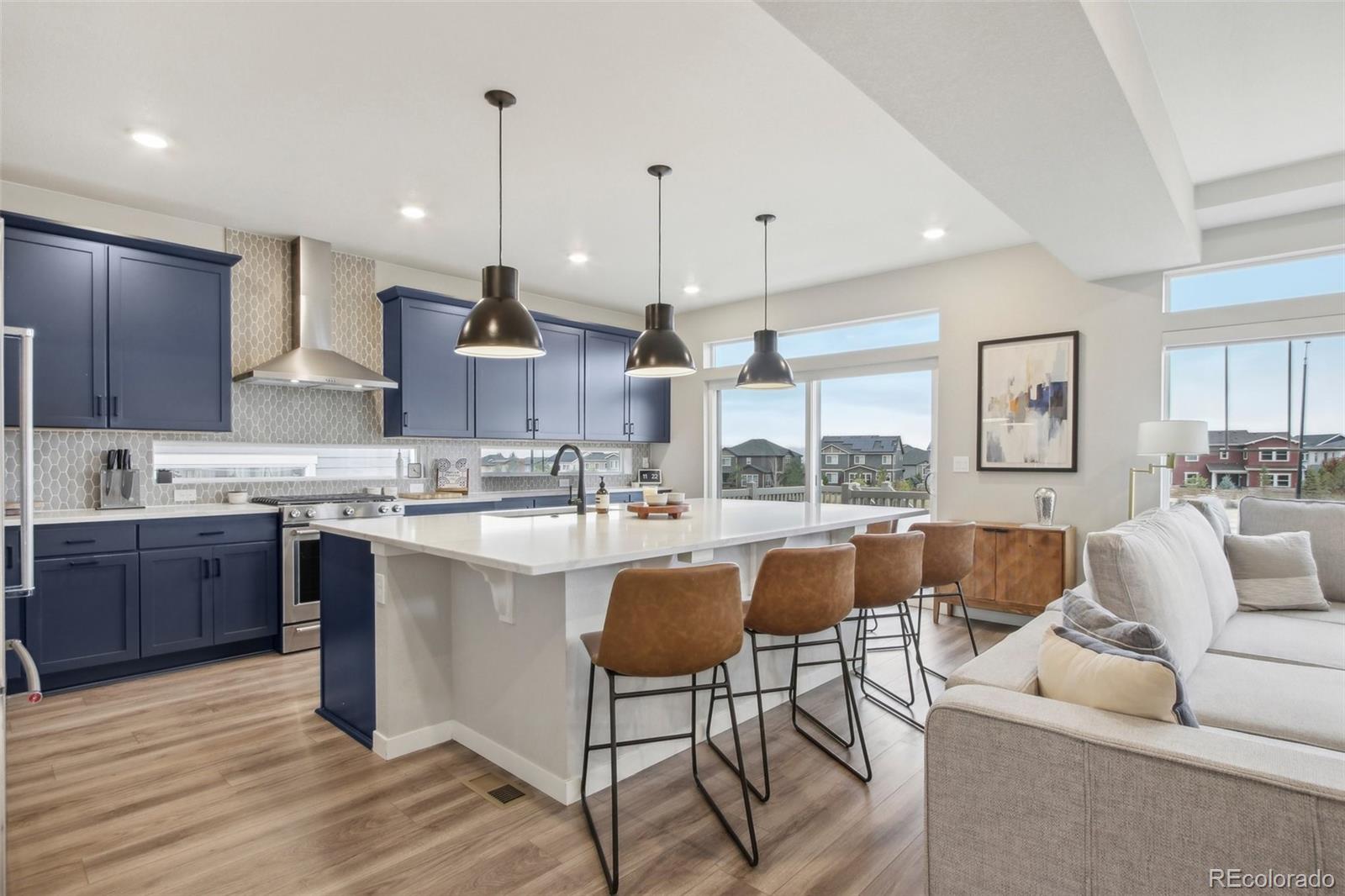 a living room with stainless steel appliances granite countertop furniture a couch and kitchen view