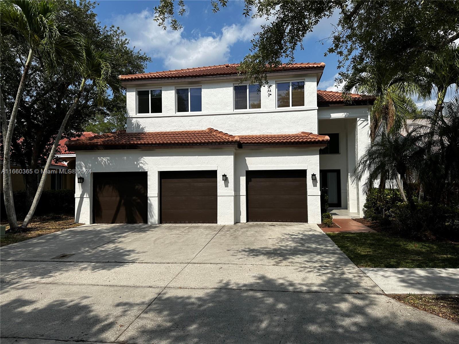 a front view of a house with yard and trees