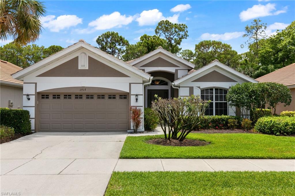 Ranch-style house featuring a front lawn and a garage