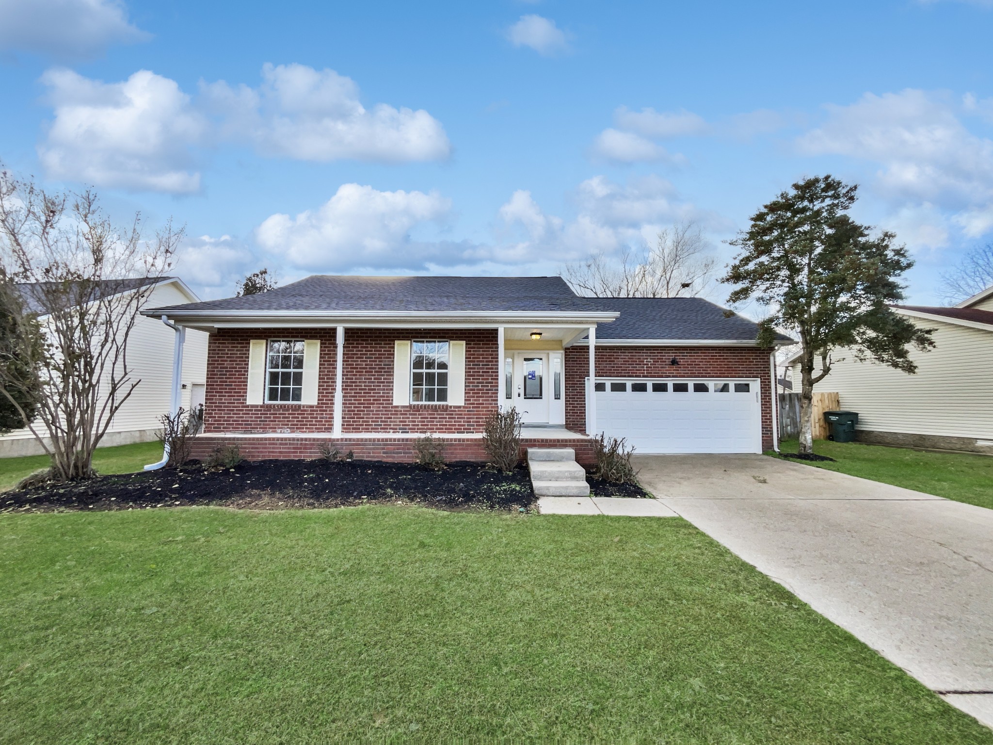 a view of a house with a yard and pathway