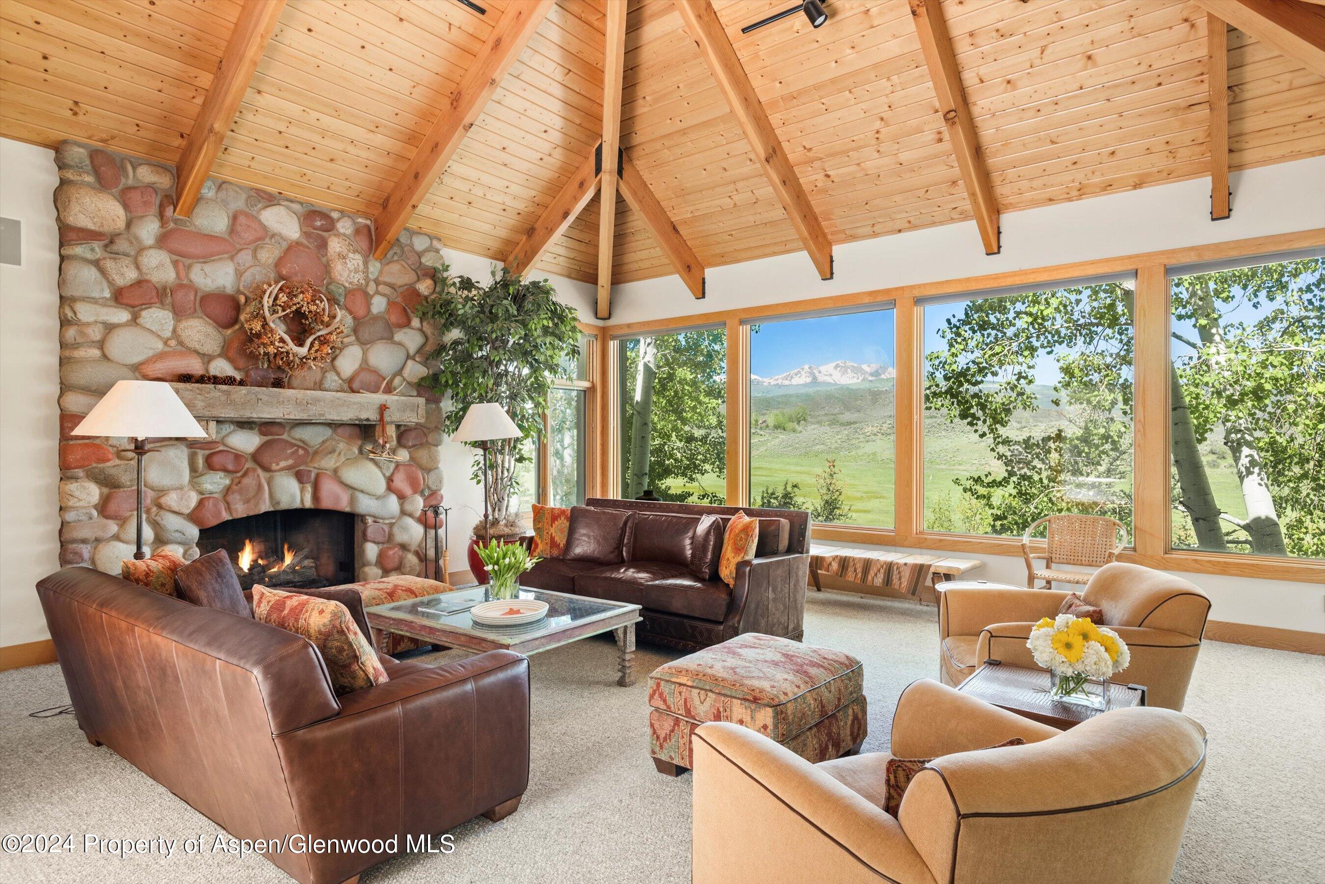 a living room with furniture a fireplace and a large window