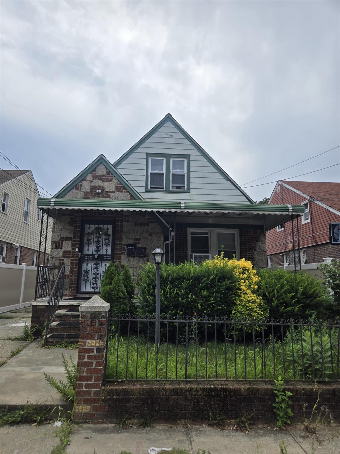 a front view of a house with a yard and potted plants