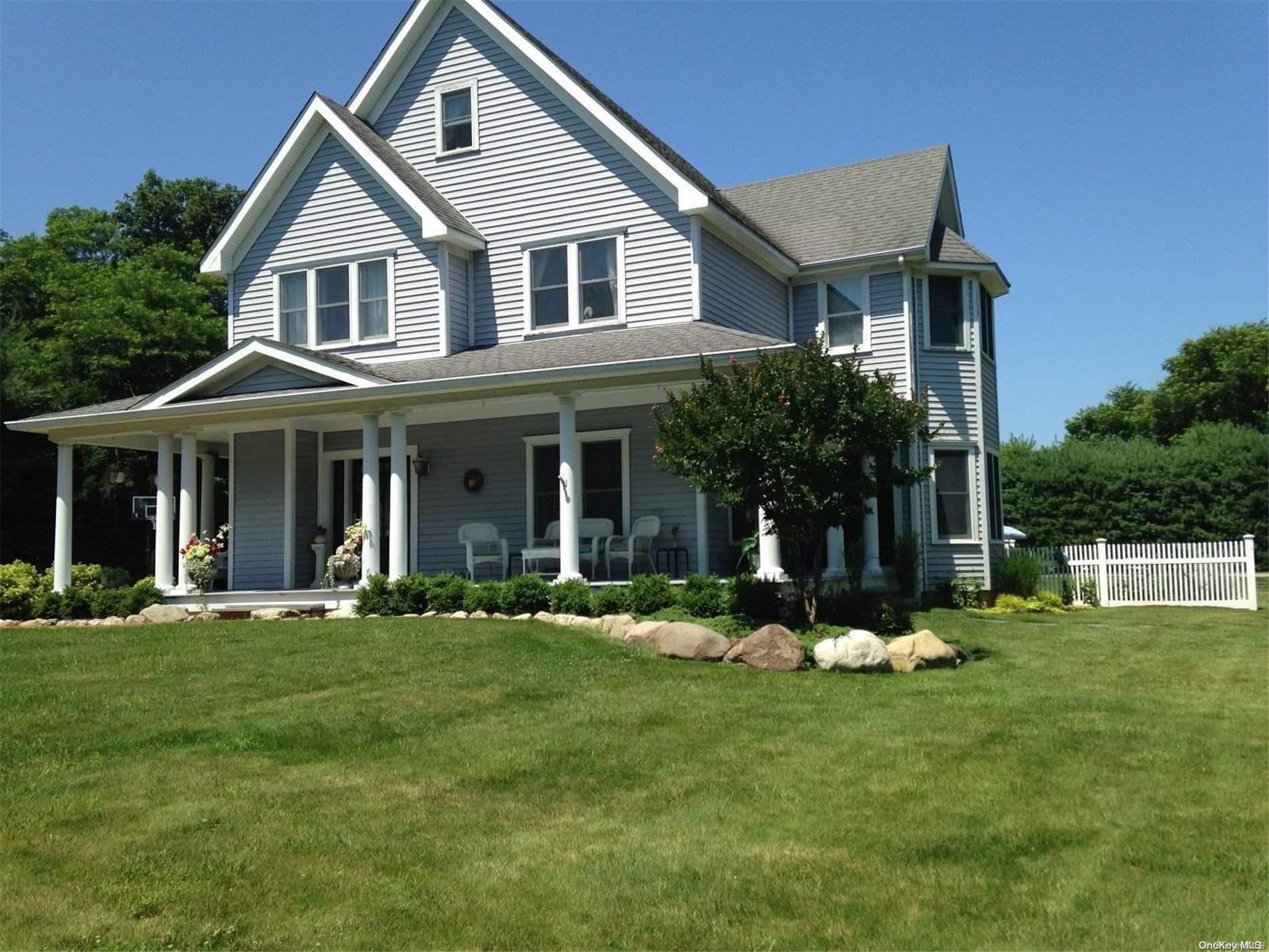 a front view of a house with a yard and trees