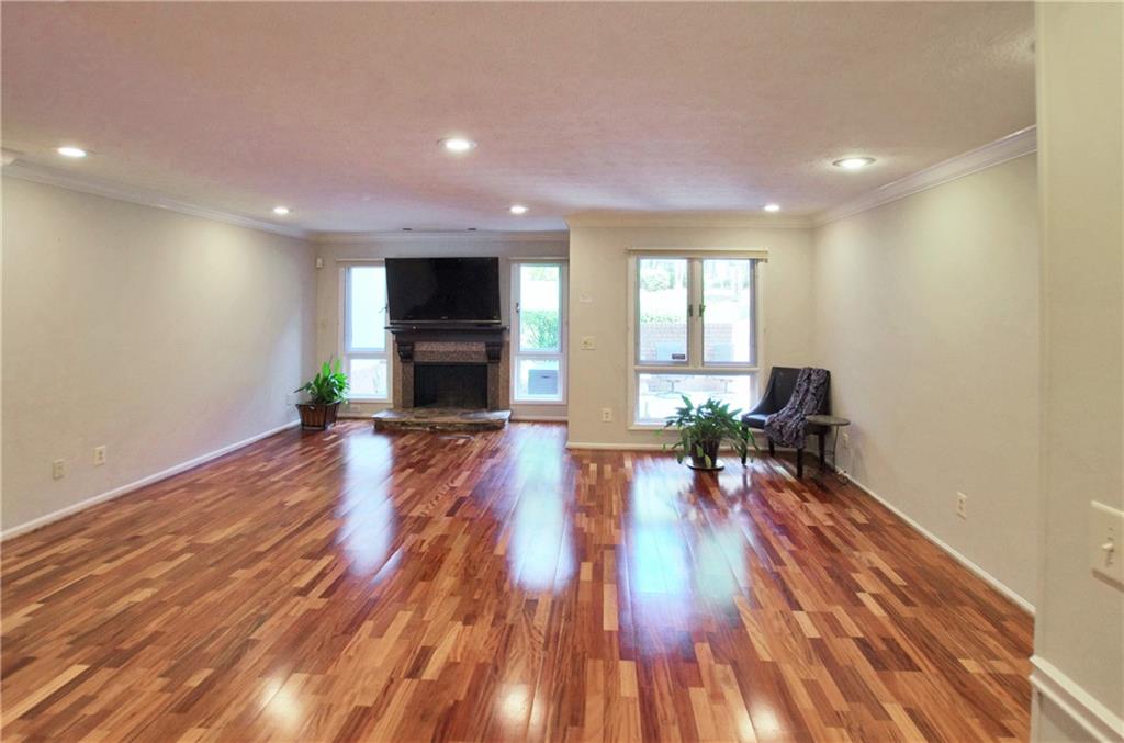 a view of a living room a dining room with wooden floor and a window