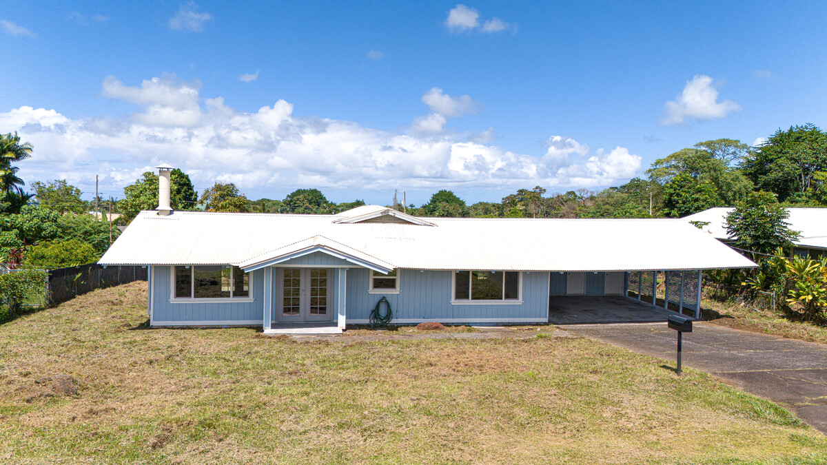 a aerial view of a house with a patio and a yard