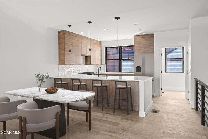 a kitchen with a table chairs sink and cabinets