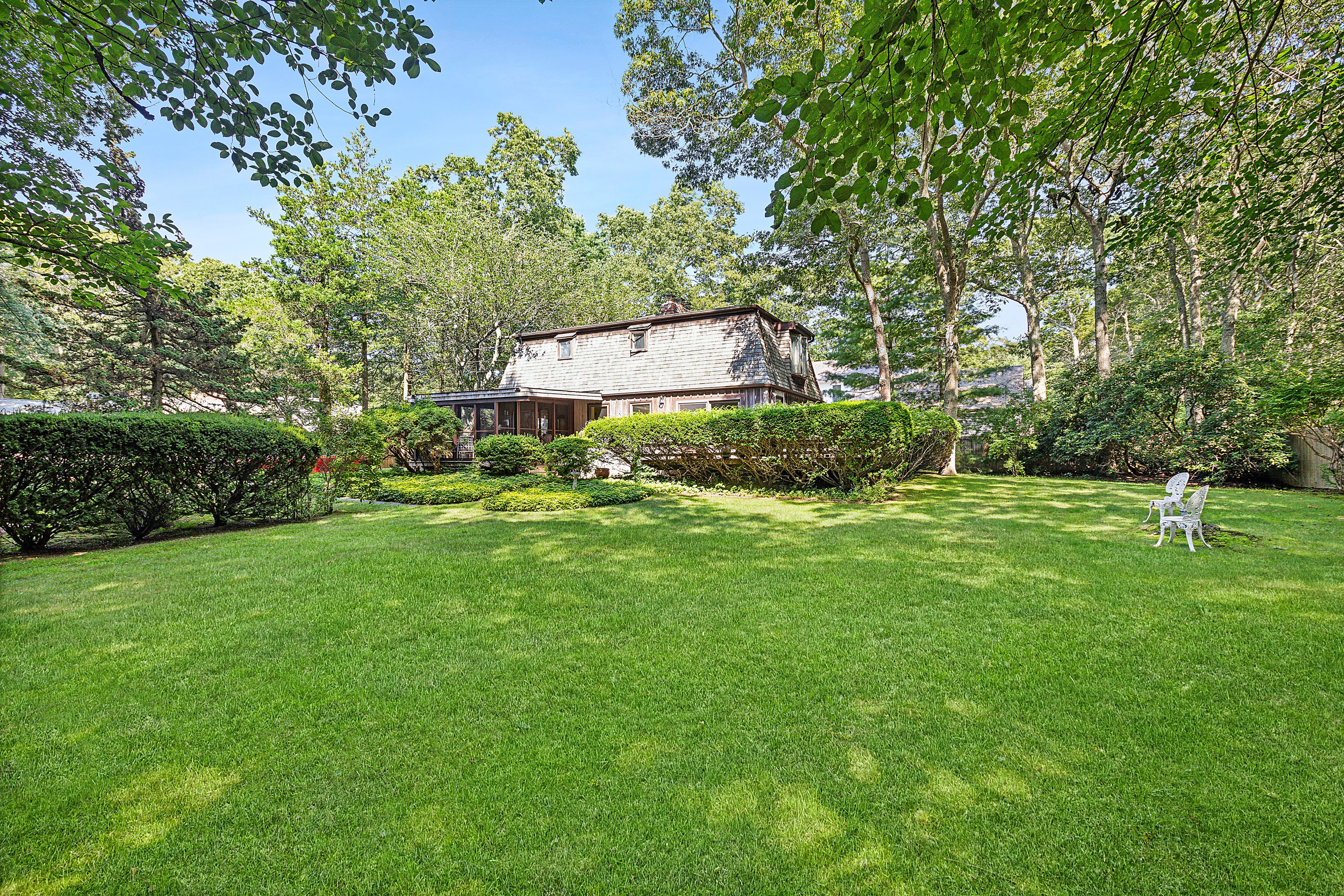 a backyard of a house with lots of green space and fountain