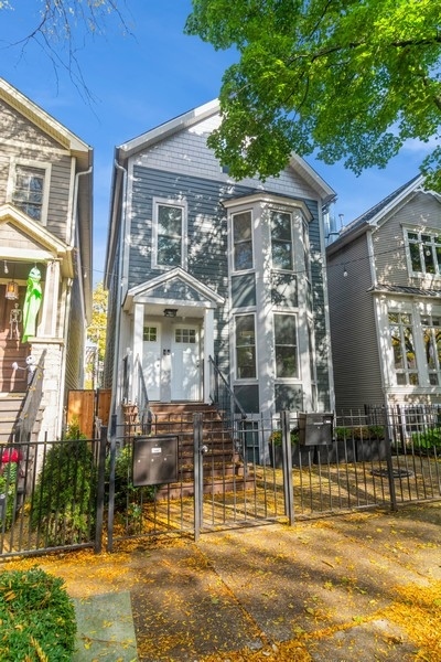 a front view of a house with glass windows and plants