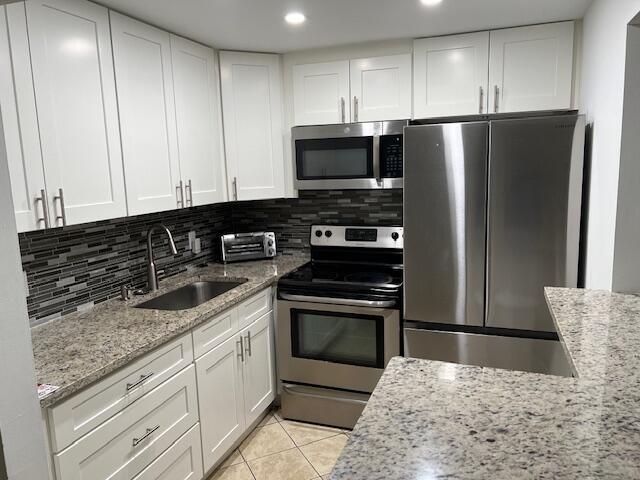 a kitchen with stainless steel appliances granite countertop a refrigerator sink and stove