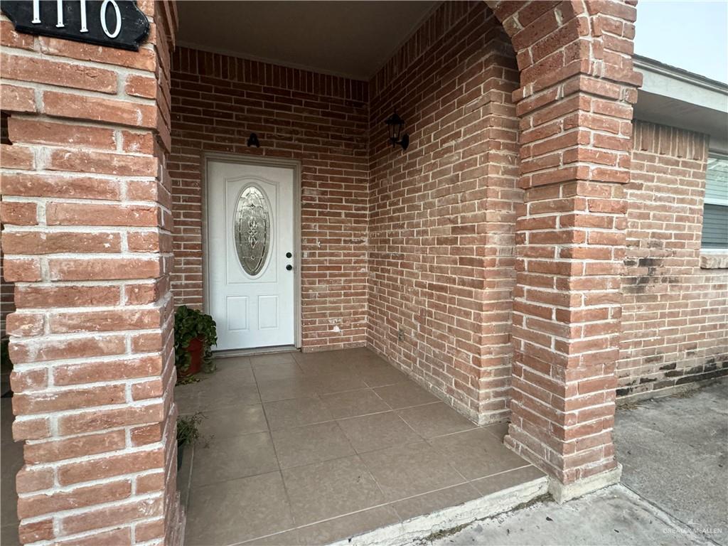 Property entrance with a yard and a patio