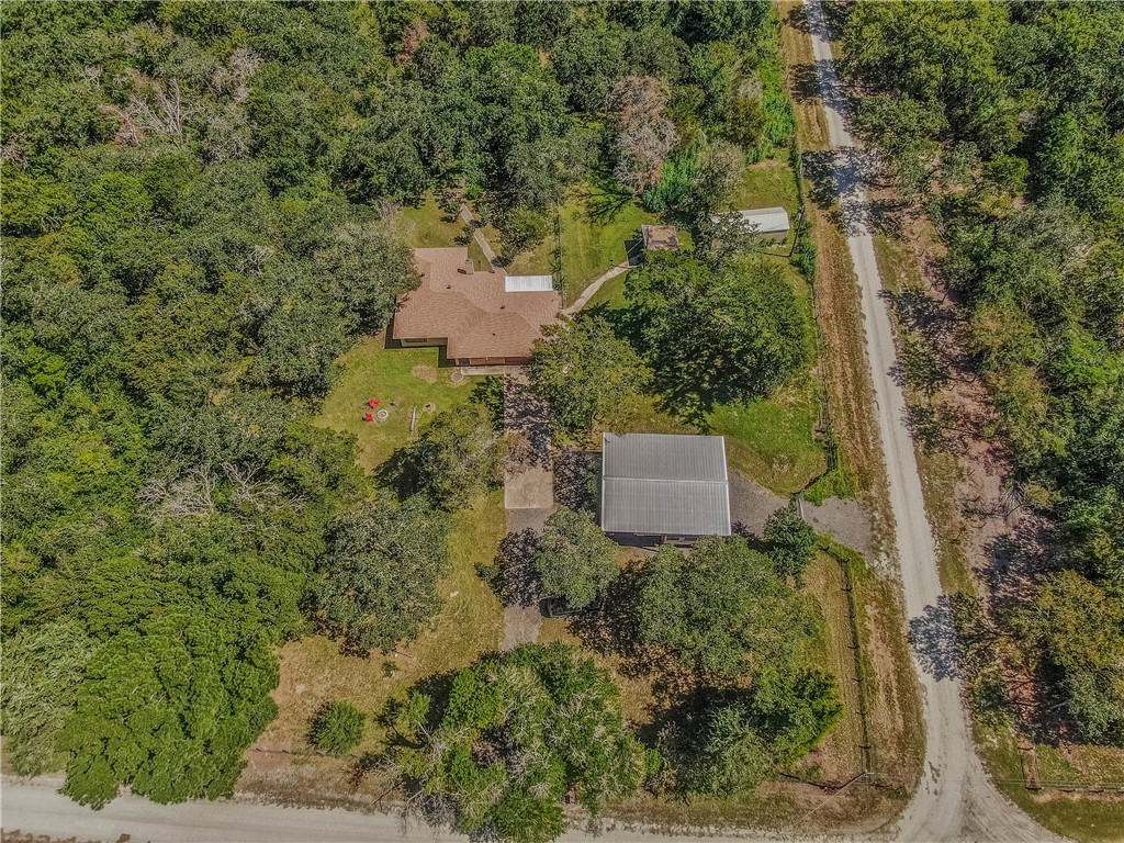 a aerial view of a house with a yard and large trees