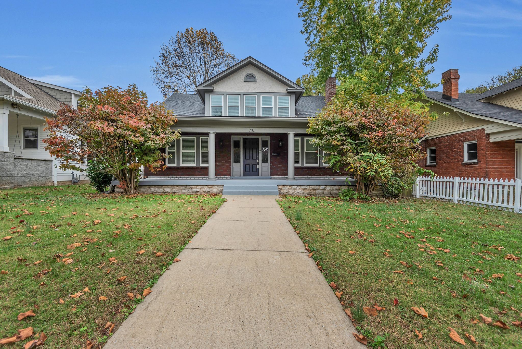 a front view of a house with a yard and potted plants