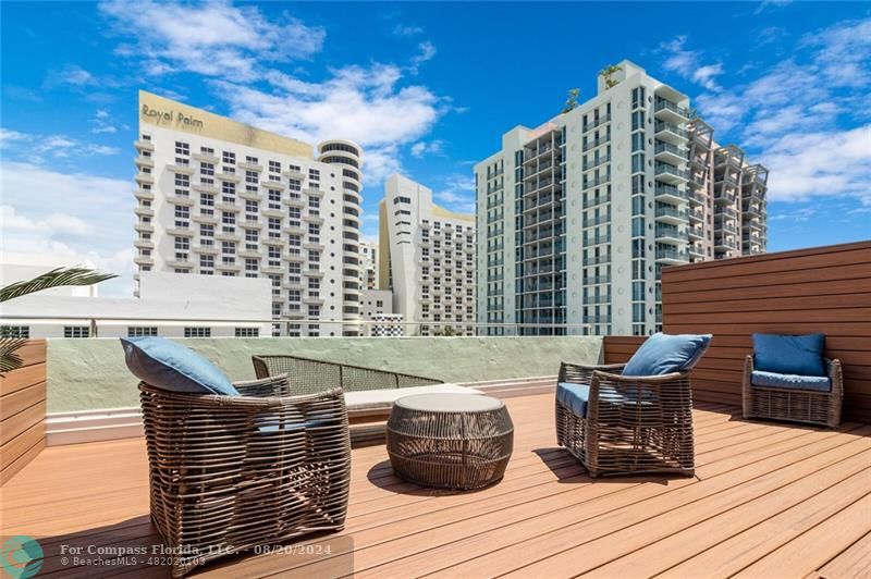 a roof deck with couch and chairs