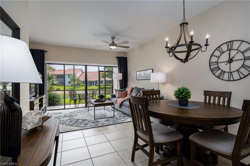 Tiled dining room with ceiling fan with notable chandelier