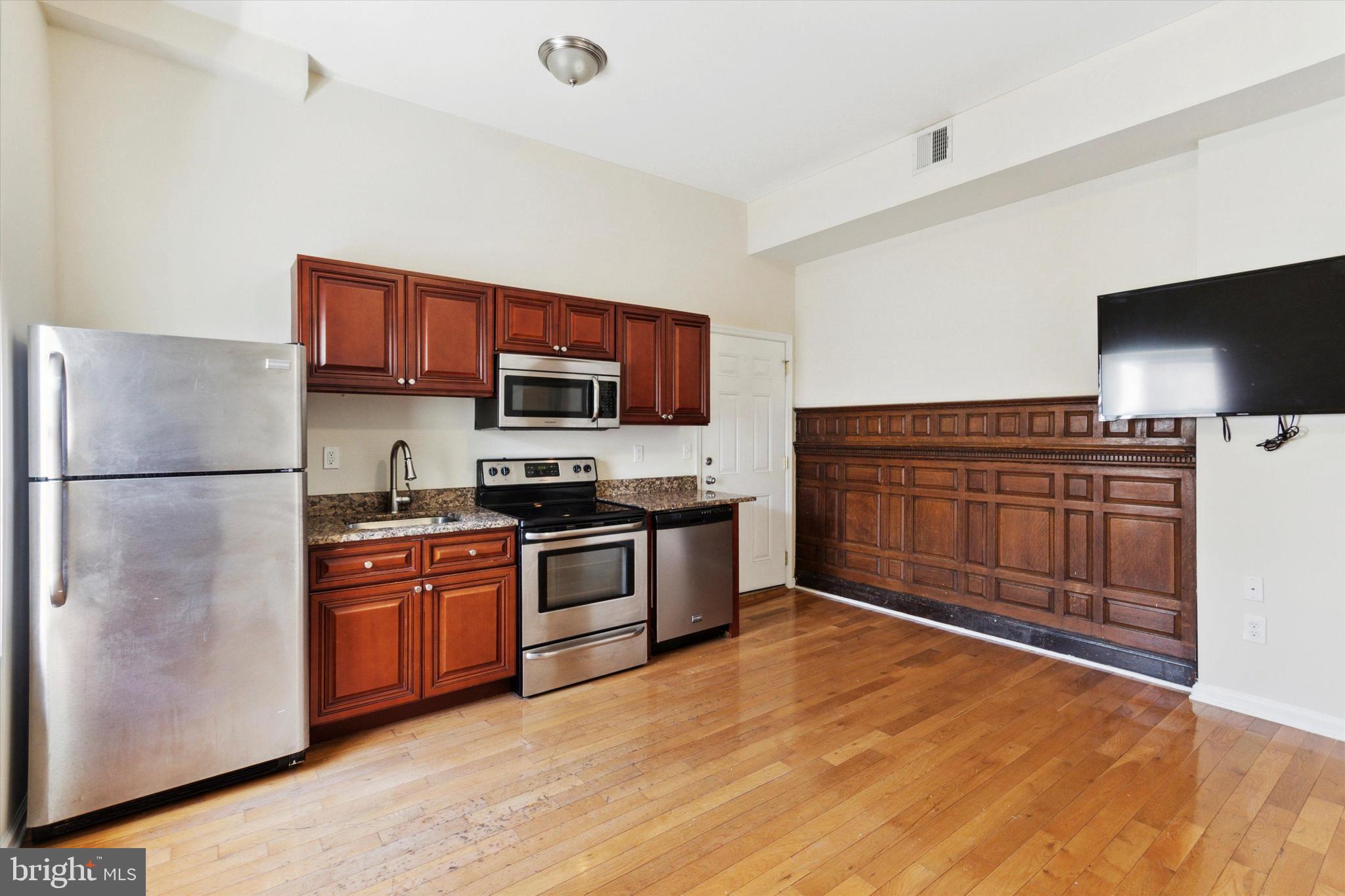 a kitchen with stainless steel appliances granite countertop a refrigerator stove and sink