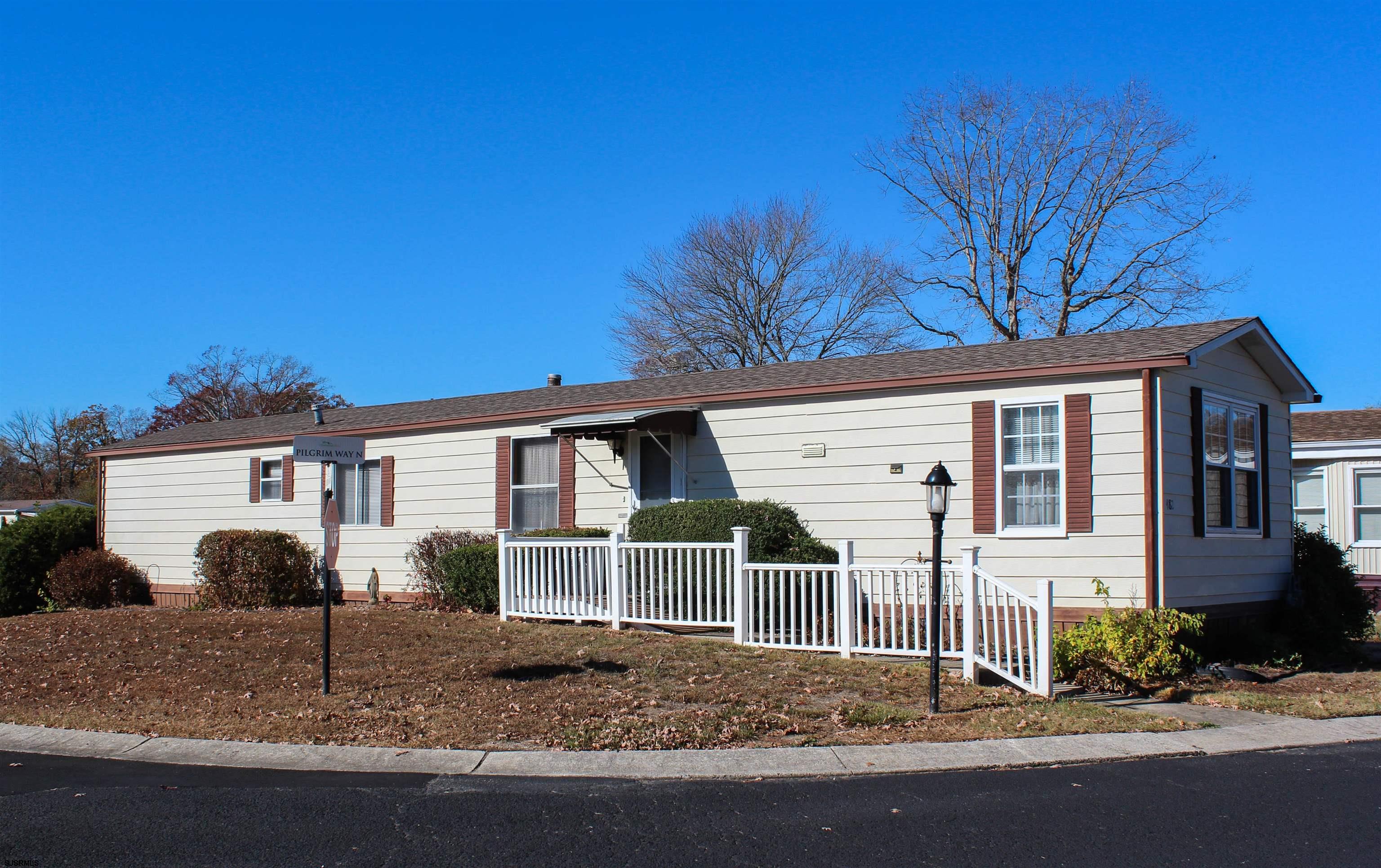 a view of a house with a yard and large tree