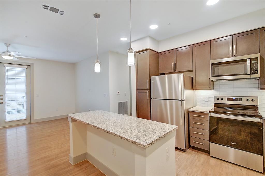 a kitchen with refrigerator cabinets and wooden floor