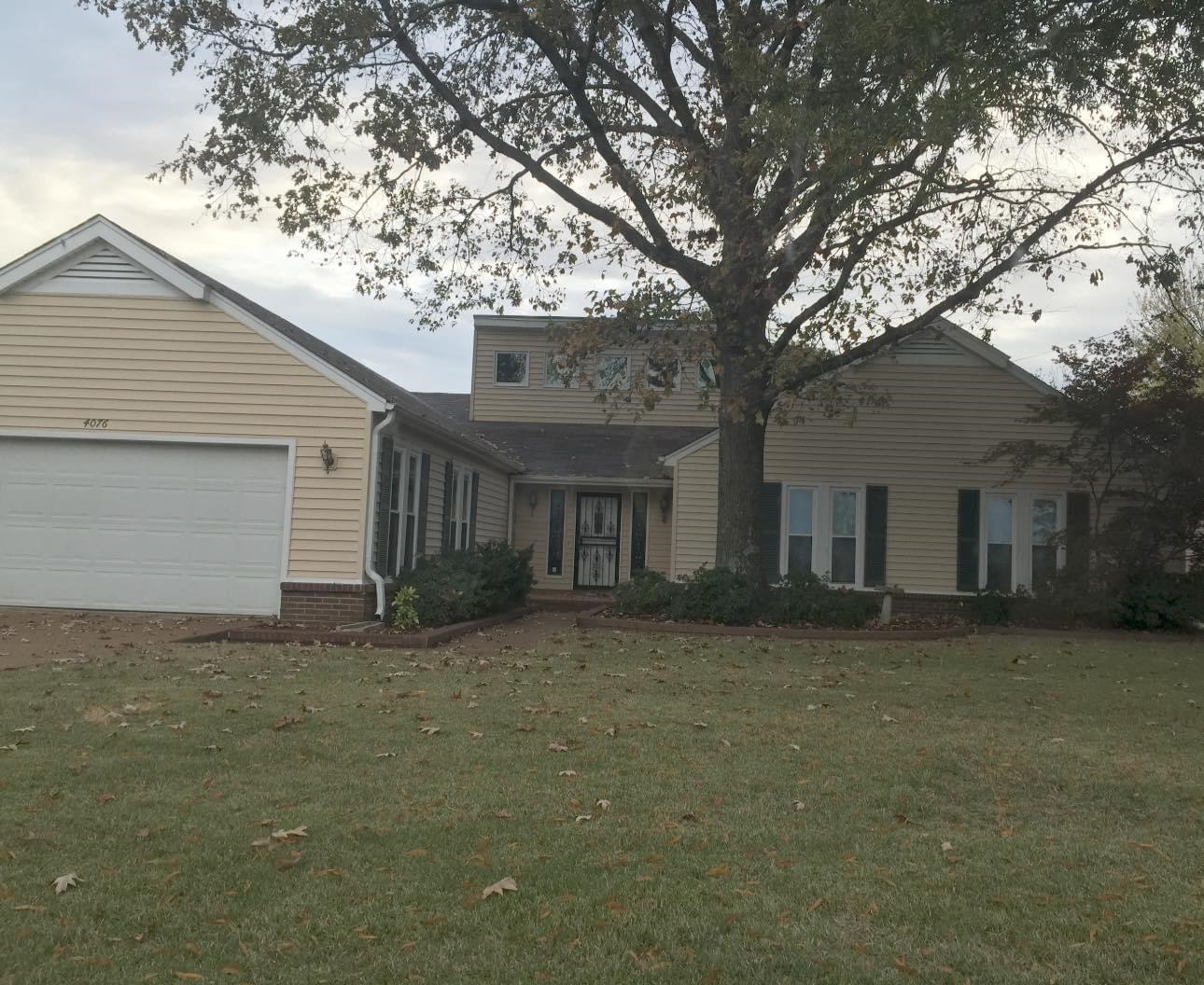 a view of a house with a large tree