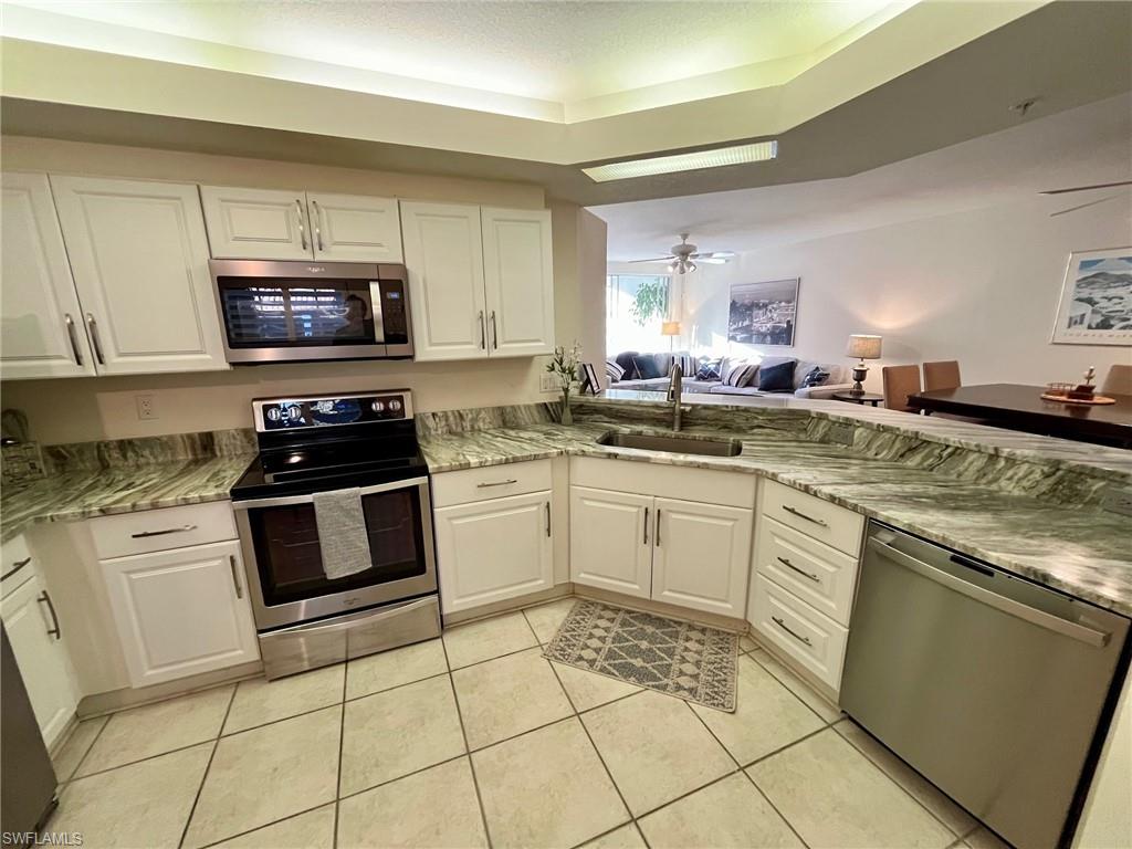 a kitchen with a sink stove top oven and microwave