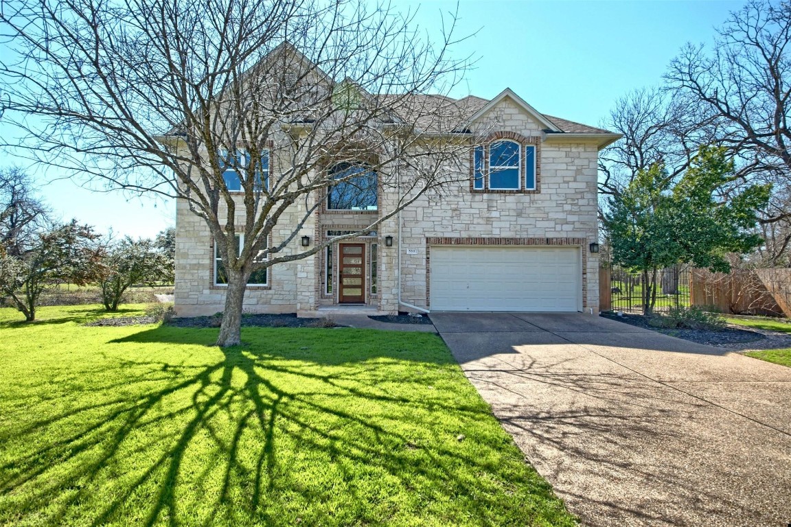 a front view of a house with a yard and garage