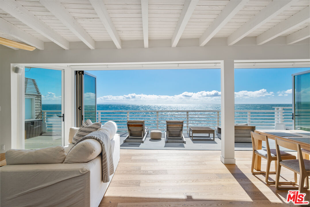 a living room with furniture and floor to ceiling windows