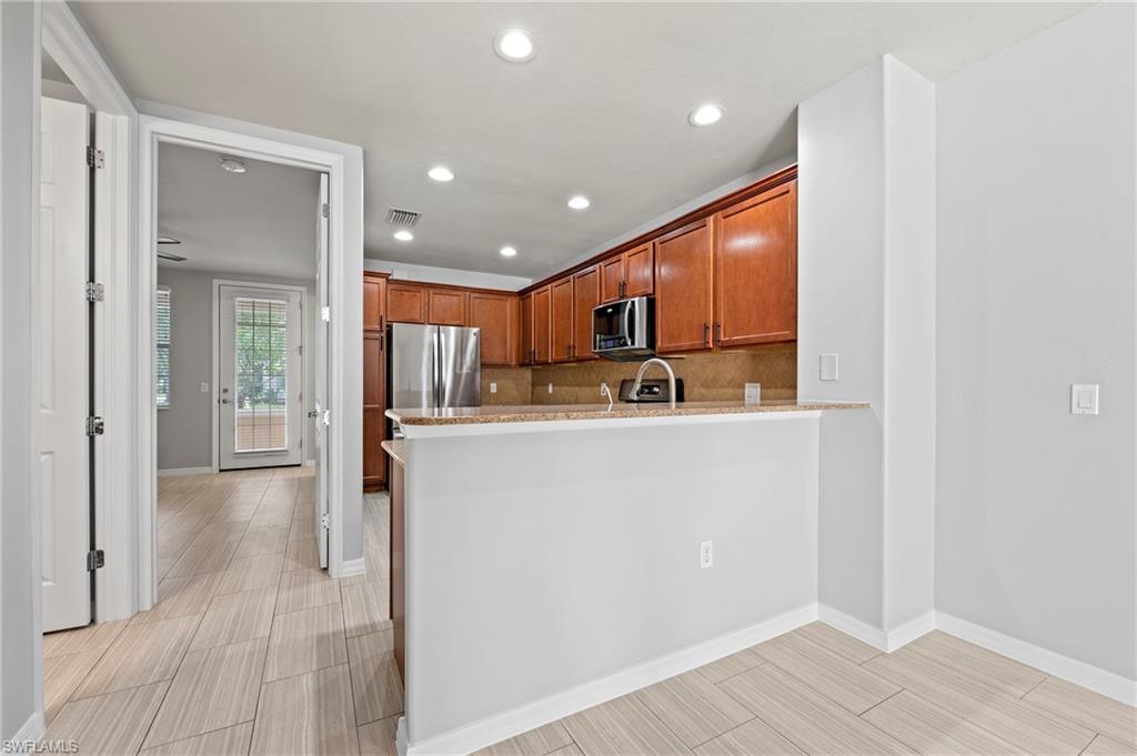 a view of kitchen with kitchen island wooden floor center island and stainless steel appliances