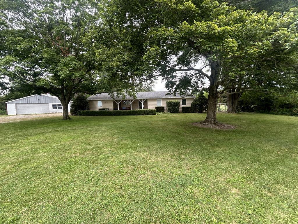 a view of a yard with a house and large trees