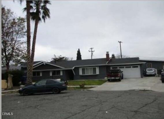 a front view of a house with a yard and parking space