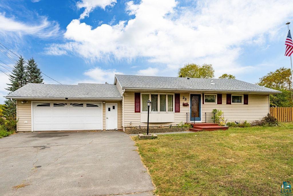 Ranch-style house with a porch, a garage, and a front lawn