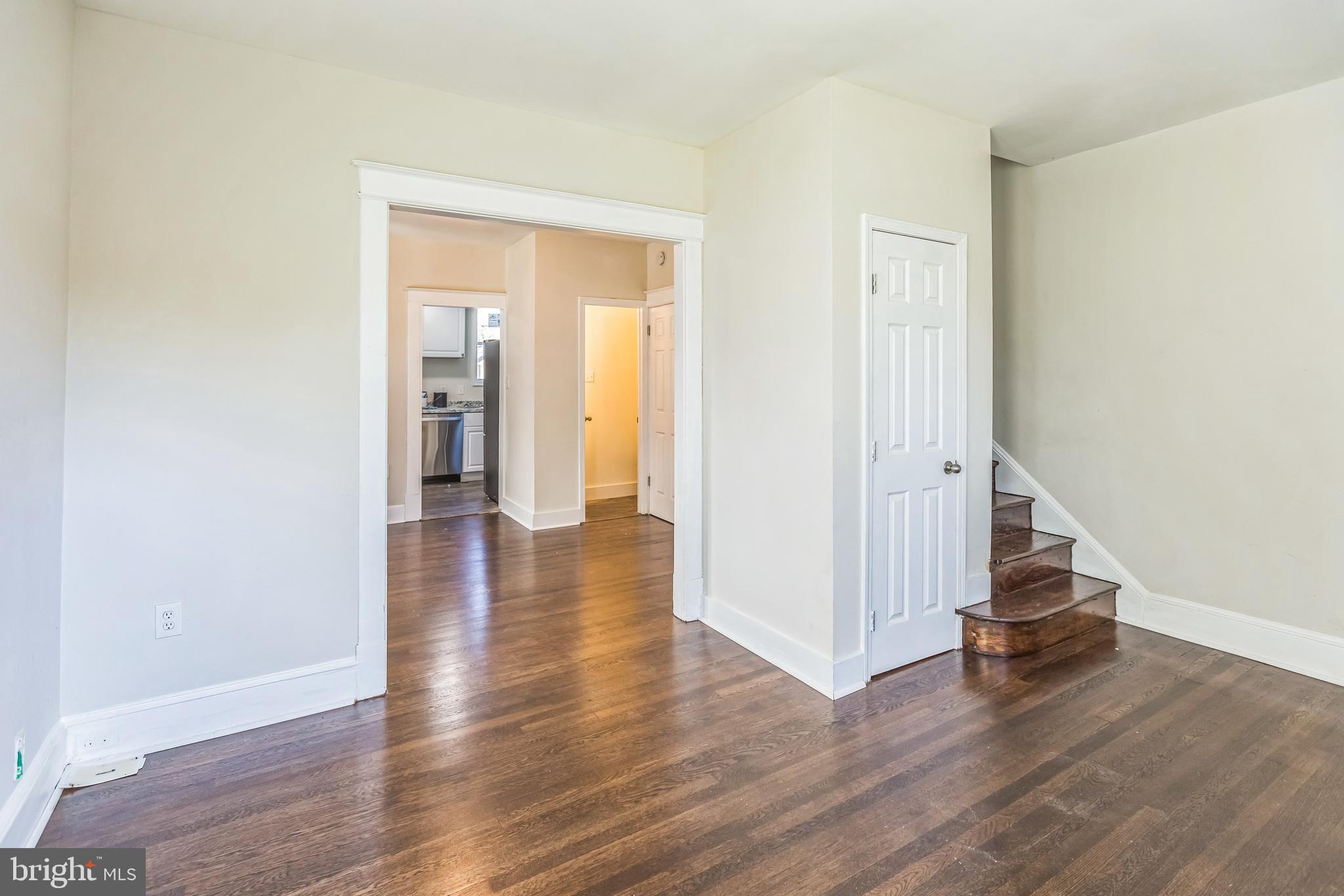 a view of a hallway with wooden floor and staircase