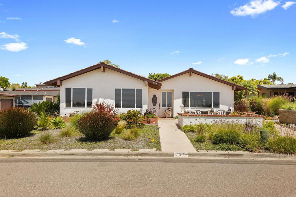 a front view of a house with a garden and plants