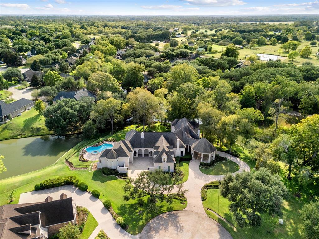 an aerial view of a house with a garden and lake view