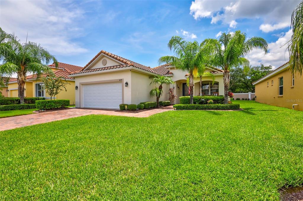 a front view of a house with a yard and trees