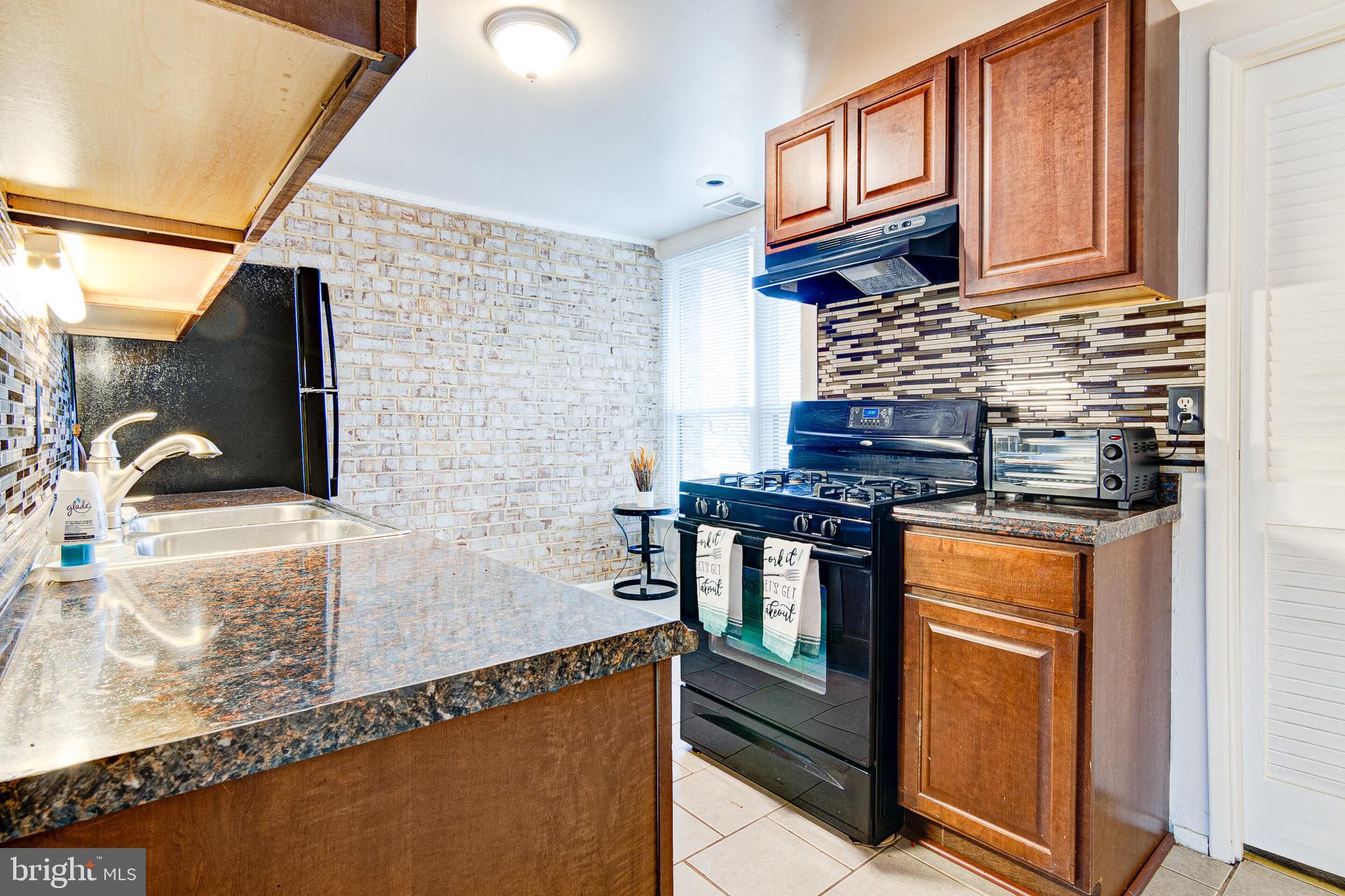 a kitchen with stainless steel appliances granite countertop a stove and a microwave