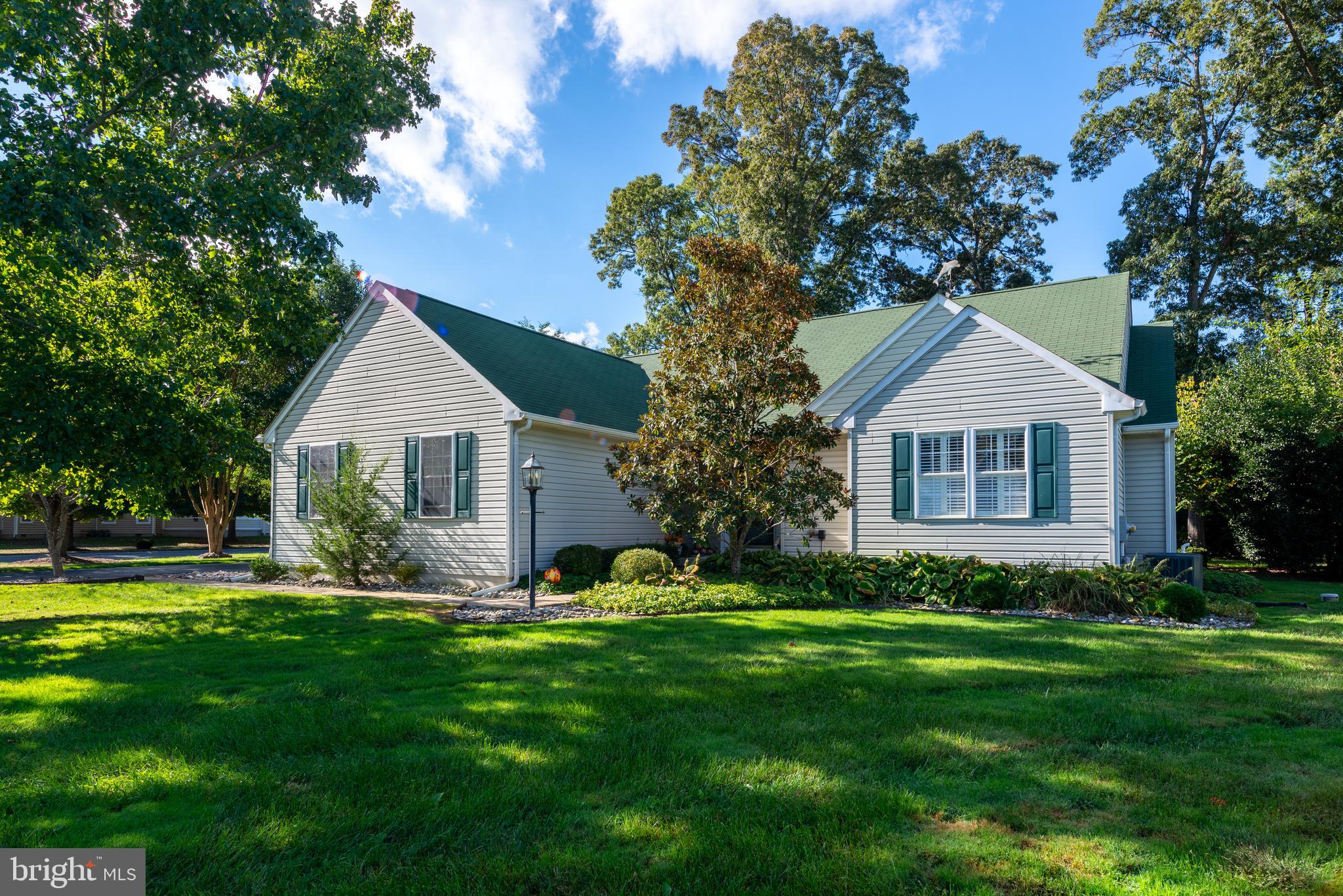 a front view of a house with a garden and trees