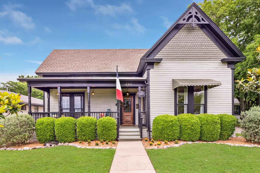 a front view of a house with a yard and potted plants