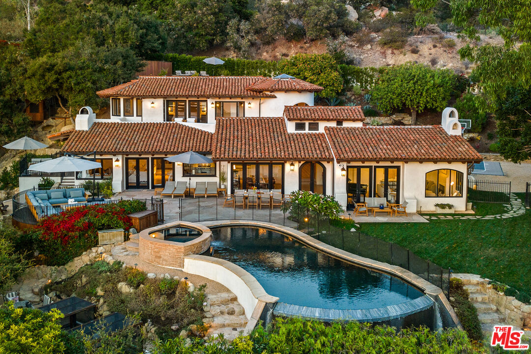 a aerial view of a house with swimming pool and a yard