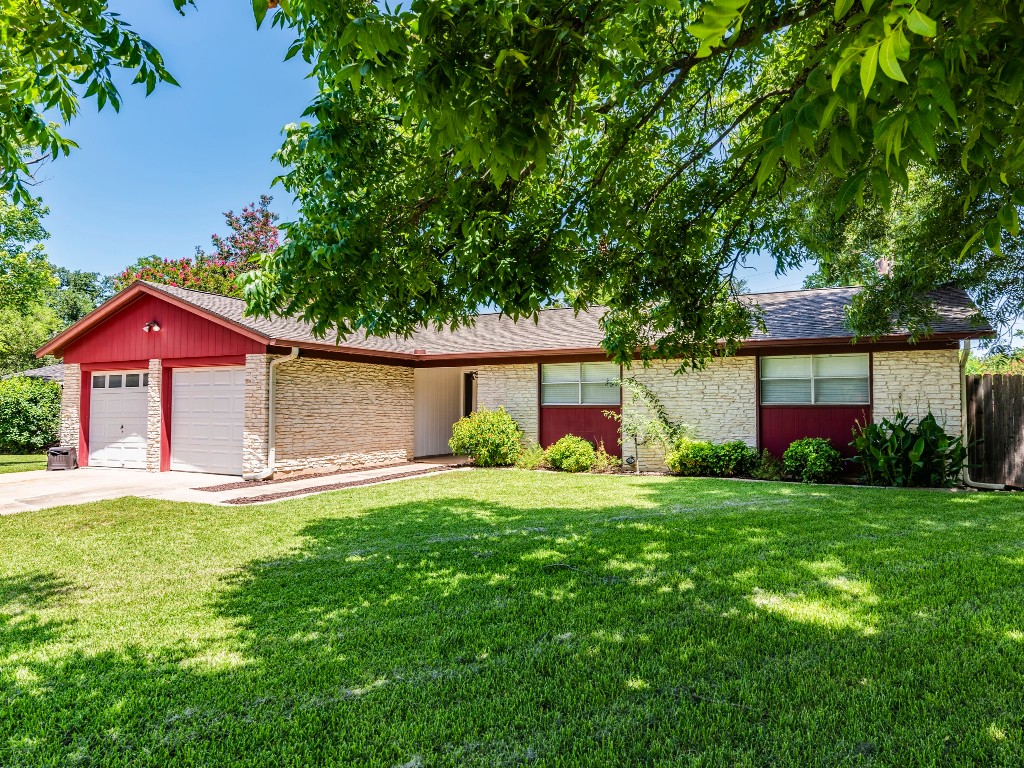 a front view of a house with a yard and trees