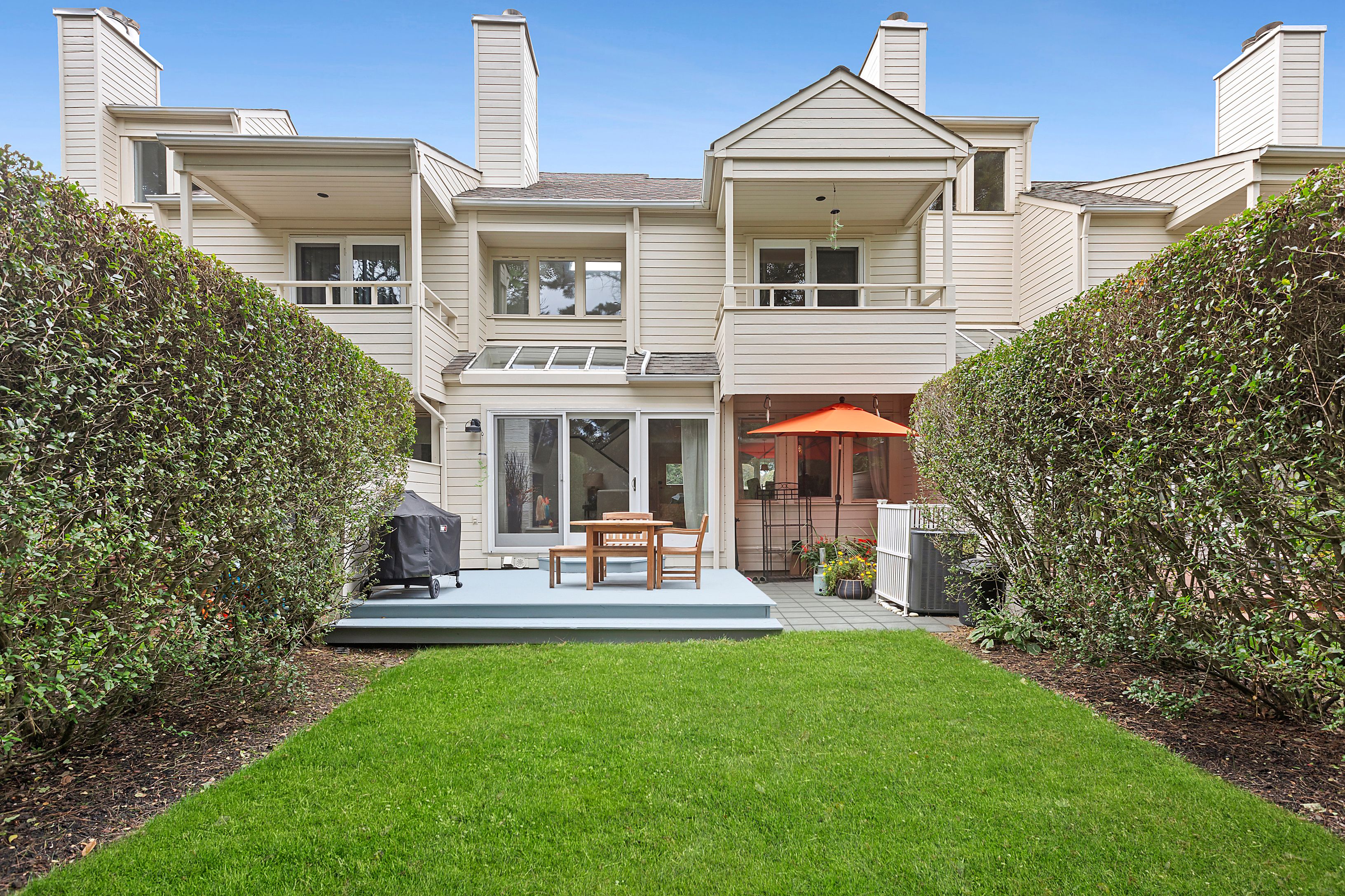 front view of a house with a yard and potted plants