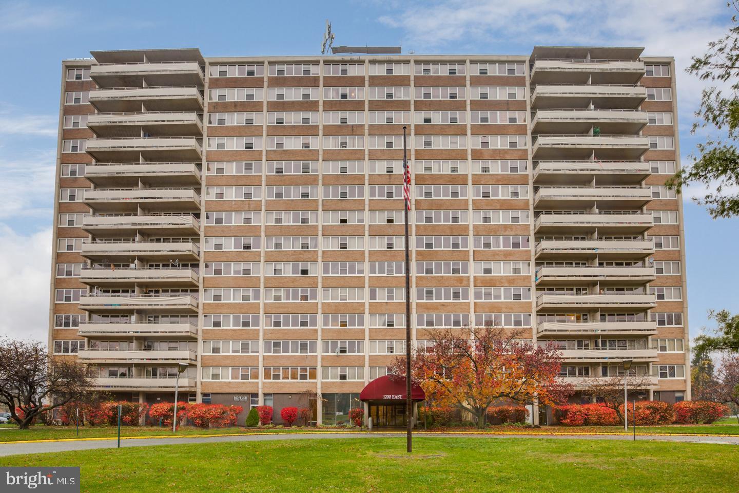 a front view of a building with lot of windows and trees