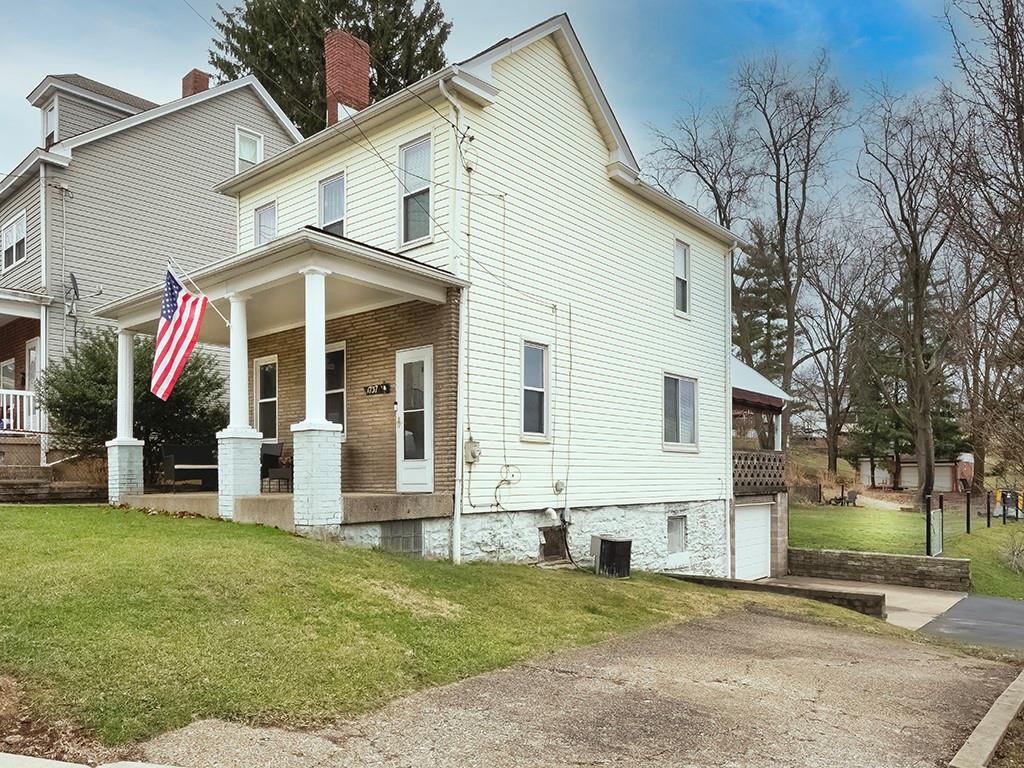 a view of a white house with a big yard and potted plants